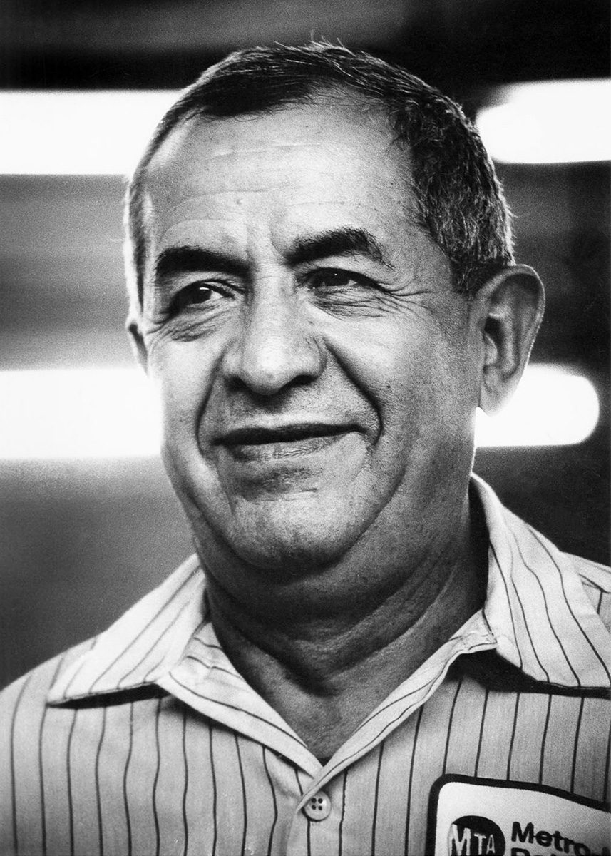 portrait of custodial man with striped collared shirt looking past the camera with slight smile