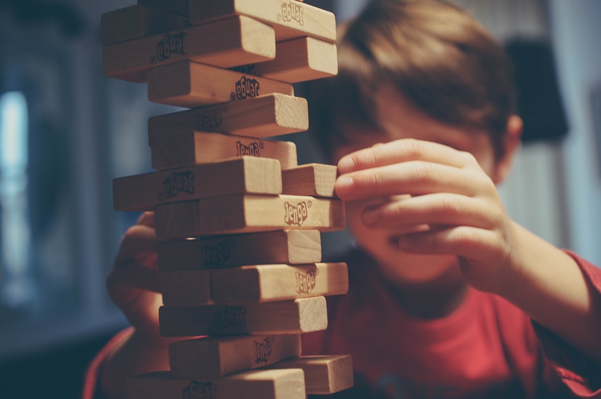 Boy playing Jenga, a board game